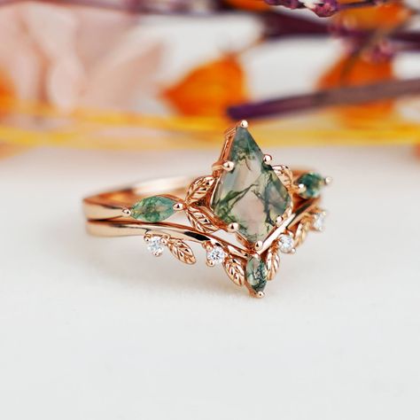 Elevate your special moments with the Leaf-Inspired Kite Cut Moss Agate Engagement Ring Set. Exquisitely handcrafted in 14k gold, this unique set features a natural moss agate gemstone, celebrated for its distinct green hues and organic patterns. The kite cut of the gemstone, nestled in a leaf-type design, adds an enchanting touch of nature-inspired elegance. Perfect as an engagement ring or a thoughtful gift for women, this ring set embodies both beauty and a deep connection to the natural worl Miss Agate And Diamond Ring, Miss Agate Kite Ring, Types Of Engagement Ring Stones, Kite Ring Set, Unique Gem Engagement Rings, Unquie Wedding Rings, Moss Rings Engagement, Rose Gold Moss Agate Engagement Ring, Unique Earthy Engagement Rings