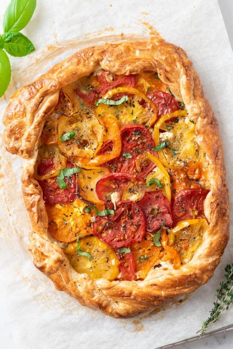 Top-down view of a tomato and feta galette on parchment paper. Tomato Galette, Tomato And Feta, Store Bought Pie Crust, New Year's Eve Appetizers, Easter Appetizers, Christmas Side Dishes, Galette Recipe, Tomato Tart, Pesto Sauce