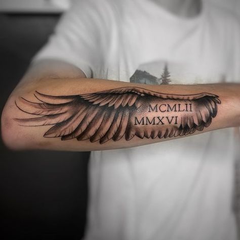 Roman Numeral Wings Tattoo, Angel Wing Roman Numeral Tattoo, Angel Wing With Name Tattoo, Angel Wing Forearm Tattoo For Men, Wing Forearm Tattoo For Men, Angel Wings Tattoo Forearm, Forearm Wing Tattoo, Forearm Name Tattoos, Arm Tattoos Black