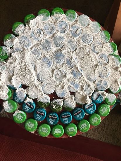 Makeover a table with saved beer caps, some glue and grout to give it a new look! #diy #diyhomedecor #table #sidetable Bottle Cap Top, Beer Cap Table Diy, Beer Cap Design, Bottle Cap Epoxy Table, Crafts With Beer Bottle Caps, Bottle Cap Table Top Diy, Beer Caps Crafts, Bottle Cap Art Diy, Diy Beer Bottle Cap Crafts