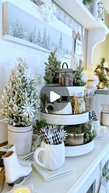 Lori 🍽️🥂 on Instagram: "Here’s a look at how I styled my hot cocoa and coffee bar for the winter this year. With the extremely cold weather we’ve having right now, I will no doubt be spending a lot of time here refilling my mug! ❄️☕️☃️⛸️☕️❄️ This is the first time I’ve used a tiered tray to hold all the hot cocoa items and I’m liking it! The coffee pods are equally handy in the canister beside my new white Keurig. Amidst the functional pieces, I’ve added wintry trees, a snowman on a sleigh, skis, skates, little houses and a snowflake garland. Two little signs flank either side of the winter scene canvas in the middle. Mittens filled with snowy greens were hung on the sideboard doors as a finishing touch. ❄️ Hope you have a wonderful weekend my friends and stay cozy! ❄️ Thanks for visit White Keurig, Hot Cocoa And Coffee Bar, Winter Hot Chocolate, Coffee Bar Kitchen, Hot Chocolate Mugs, Have A Wonderful Weekend, Snowflake Garland, Bar Inspiration, Tray Styling