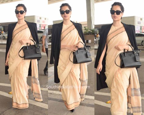 Kangana made a fashion statement at the airport in a simple peach color cotton saree that cost just Rs.600. She paired it with a matching round neck blouse, black Givenchy trench coat and Prada bag. Saree With Trench Coat, Saree With Coat Winter, Nifty Videos, Interview Outfits Women, Interview Outfits, Round Neck Blouse, Kangana Ranaut, Beautiful Sarees, Latest Designer Sarees