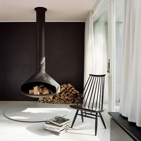 A Hanging Fireplace And Black Accent Wall Stand Out In This Modern Living Room Focus Fireplaces, Design Camino, Atrium House, Hanging Fireplace, Floating Fireplace, Freestanding Fireplace, Scandinavian Interior Design, Courtyard House, Modern Fireplace