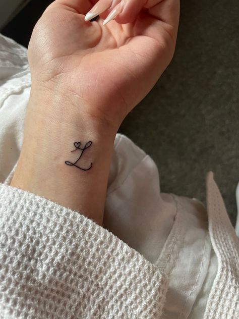 L initial tattoo with heart Tattoos For Initials, Letter On Hand Tattoo, Partner Name Tattoo Ideas, Red Ink Initial Tattoo, Small Tattoos Initials Letters, Spouse Initial Tattoo, Small L Tattoo, L Tattoos For Women, L Heart Tattoo