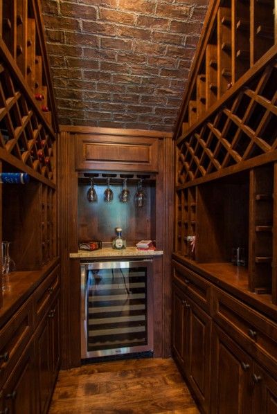 This small wine room found on sebringdesignbuild.com packs a big design punch. The authentic details, wood brick, and stone help to create a warm, cozy feel. #smallwineroom #authenticwineroom #oldworldwineroom #winetastingroom #customwineshelves #brickceiling Wine Interior Design, Wine Cellar Closet, Stair Shelves, Cellar Ideas, Design Stairs, Wine Cellar Basement, Rustic Stairs, Wine Closet, Tiny House Stairs