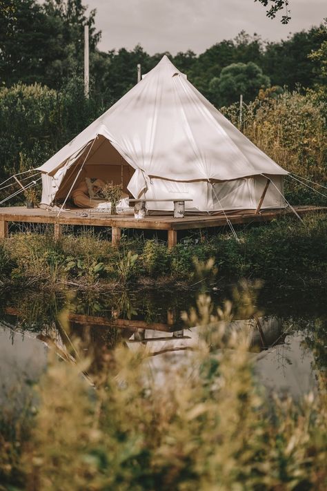 One of the best glamping tents, a canvas bell tent, on a wooden platform beside a pond surrounded by vegetation. Bell Tent Glamping, Luxury Camping Tents, Tents Camping Glamping, Bell Tent Camping, Tent Platform, Tents For Camping, Canvas Bell Tent, Four Season Tent, Auto Camping