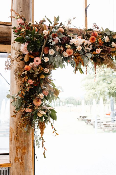 A Burnt Orange & Modern Winery Wedding in Beaconsfield Upper at a rustic winery setting. A colour palette of peach, orange and Grace loves lace. | Photo by https://www.zoelouisephotography.com/ | Polka Dot Wedding Rustic Wedding Orange, Sage Green Burnt Orange And Cream Wedding, Pink And Amber Wedding, September Wedding Inspiration, Rustic Orange Wedding, Burnt Orange Wedding Arch Flowers, Rust Wedding Arch Flowers, Winery Wedding, Autumn Wedding Arch Ceremony Backdrop