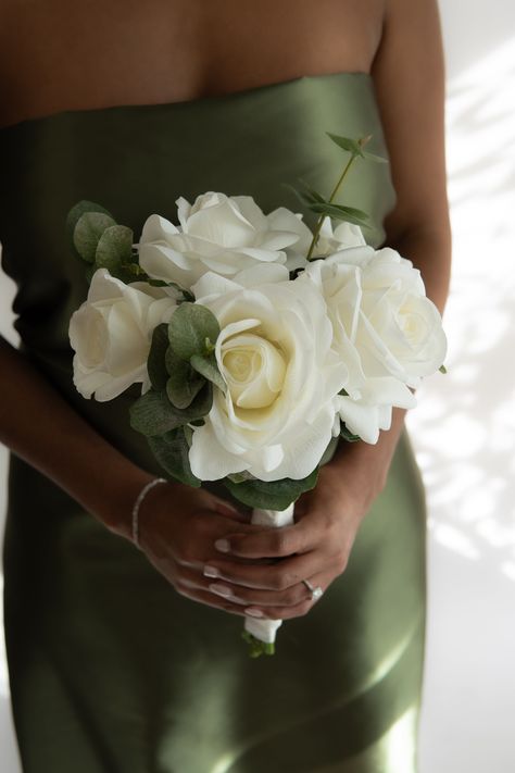 The "Callista Bridesmaid Bouquet" is a blend of romance and elegance for the modern bridesmaid. Made with a mix of "real touch" petite alba, alba, and hybrid tea roses and premium silk silver dollar eucalyptus. Stems wrapped with ribbon. No glue, no tape, no mess. Sold individually. Measures 7.5" wide and 13" tall. Pairs perfectly with the "Callista Centerpiece" and "Callista Bridal Bouquets." Our blooms, like your love, last forever – a perfect gift for your bridesmaids to take home!