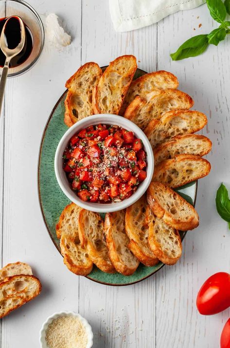 Fresh basil and vine-ripened tomatoes make this classic bruschetta recipe perfect for summer get-togethers! The bread can be toasted in the oven or grilled, and it’s easy to make in advance so you can get a head start on your party prep! | tomato basil bruschetta recipe | bruschetta with tomato and basil | tomato basil bruschetta appetizers | tomato bruschetta with garlic and basil | tomato and basil bruschetta Bruschetta With Tomato And Basil, Tomato And Basil Bruschetta, Italian Canapes Appetizers, Italian Bruschetta Aesthetic, Italian Food Ideas For Party, Bruschetta Presentation, Bruschetta Ideas Appetizers, Appetizer Italian Appetizers, Italian Entrees Appetizers