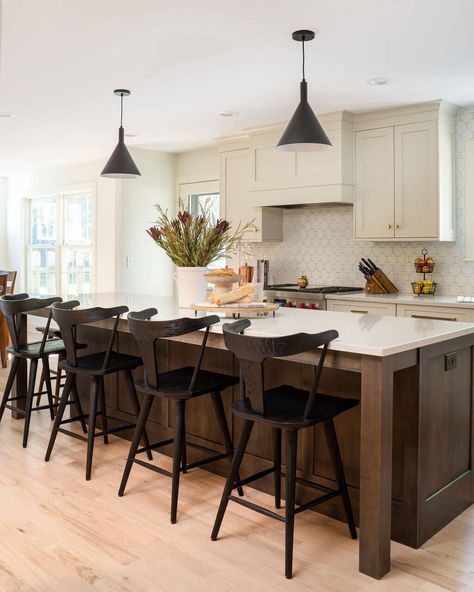 This peaceful modern farmhouse features Dura Supreme’s off-white “Putty” paint. Inspired by nature, this soft, natural paint finish creates a warm, comfortable, and relaxing mood to the home. The designer used the “Putty” paint for the majority of the kitchen cabinets, the integral canopy wood hood, and the main floor bathroom vanity on the Hudson door style. The kitchen island uses a dark “Praline” stained finish to add a nice contrast to the painted kitchen cabinetry. Putty Kitchen, Warm Kitchen Ideas, Dura Supreme Cabinets, Contrasting Kitchen Island, Walnut Kitchen Island, Wood Hood, Dark Wood Kitchen Cabinets, Taupe Kitchen, Kitchen Cabinet Inspiration