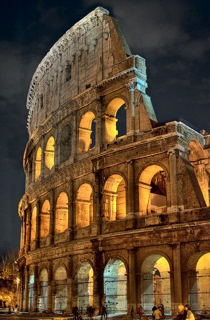 Okay, so the Colosseum wasn't built as of A.D. 65, but the amphitheaters and circuses of the day had a similar presentation, with multi-story archways and pillars (Source: Flickr, Captain Blackadder, The Colosseum at Night) Rome Italy, Rome Italy Colosseum, Istoria Artei, Colosseum Rome, Roman Ruins, The Colosseum, Famous Landmarks, World Trade Center, Albania