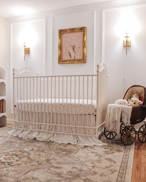 Ornate gold frames, wall sconces, and our Camellia crib make up the best nursery trio. @imbrianahill did an amazing job styling this elegant nursery! #girlnursery #homedecor #eleganthomes Vintage Gold Nursery, French Country Baby Nursery Ideas, Maeve Nursery, Elegant Baby Girl Nursery, Crib In Front Of Window, Gold Crib Nursery, Charlotte Nursery, Classy Nursery, Elegant Baby Nursery