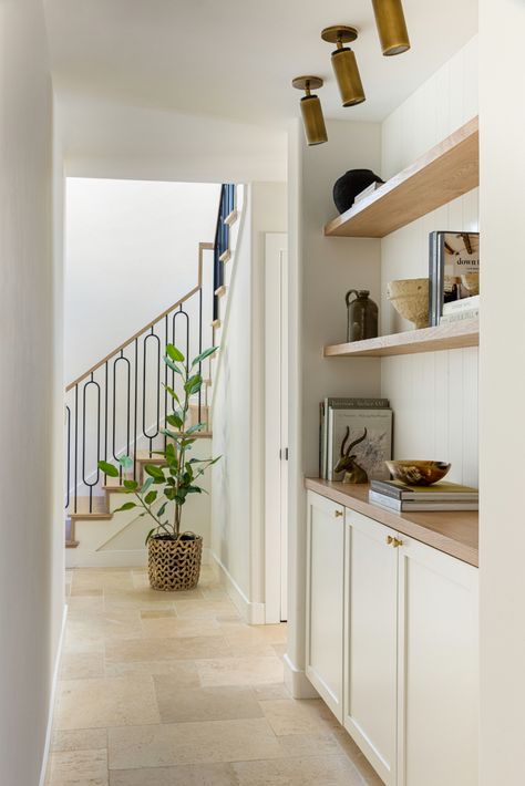 Flowing Travertine Floors Set the Tone in This Modern Mid-Century Home · Haven Country Hallway, Hallway Landing, Floating Wood Shelves, Dark Wood Dining Table, Modern Classic Home, Neutral Dining Room, Wood Staircase, Travertine Floors, Wood Front Doors