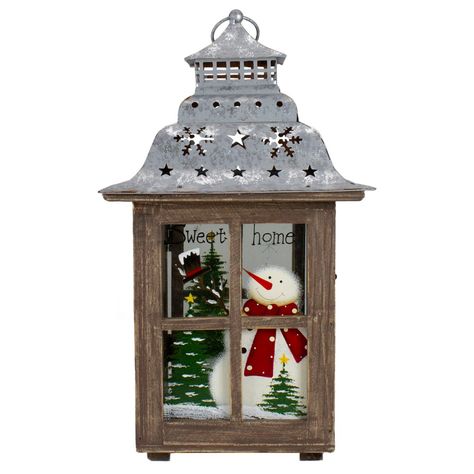 Add this Rustic holiday lantern to your holiday decor. The lantern features a brown wooden frame and surrounding glass panes painted with snow, 3 pine trees, and snowmen, just the right piece to impress your guests. You can place the lantern on your mantel, end table or even given away as a gift to that special someone on your list. Features: holiday lantern tabletop decor Features a snowman, 3 pine trees with a yellow star, and snow The roof of the lantern is silver with cutout stars and snowfl Holiday Lanterns, Snowflake Cutouts, Silver Candle Holders, Wooden Snowman, Christmas Tabletop Decor, Outdoor Hanging Lanterns, Christmas Tabletop, Candle Lantern, Christmas Central