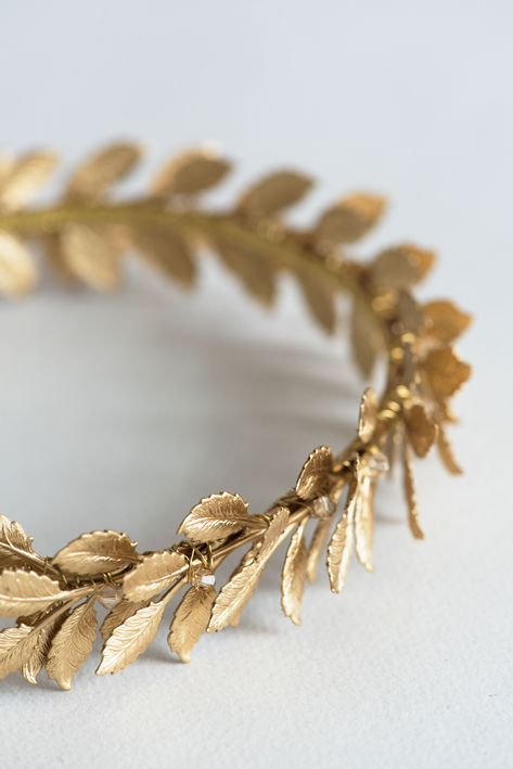 This Roman laurel leaf wreath inspired wedding crown crafted from Swarovski crystals and many high-quality golden leaves. This bridal tiara sparkles from every angle, making sure that all eyes will be in you. Looks stunning worn at weddings, anniversaries and many other special occasions. Measures: adult size. Used materials: Swarovski crystal beads, metal leaves, metal headband. Available colors: Crystal color: * clear crystal * gold crystal (shown) * custom color (ask first) Packed carefully i Greek Golden Leaf Crown, Golden Wreath Crown, Gold Circlet Crown, Gold Laurel Wreath Crown, Laurel Wreath Aesthetic, Golden Laurel Crown, Golden Leaf Crown, Greek Leaf Crown, Roman Crown