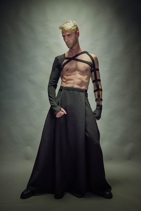 "Black men's maxi skirt with hidden pockets. It is made of a polyester jersey. The skirt has some stretch so it's comfortable for daily wear. The garment is sewn with Eloflex thread which minimizes the risk of seam breakdown on stretch fabrics. The skirt's belt fastens with a Fidlock magnetic buckle. Both, the inner belt and belt with the buckle are adjustable. The garment is easy to care for - cold machine wash, no tumble dry.  Key Features: - Adjustable waist. - Hidden pocket. - Made with spec Men's Skirts Fashion, Gender Bending Fashion Men, Flamboyant Poses Male, Fae Fashion Male, Weird Mens Fashion, Men’s Haute Couture, Men In Dresses Art, Man In Skirt Outfit, Men’s Skirt