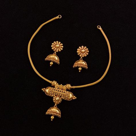 Jukti Maduli Necklace: This dainty 22K handmade gold necklace comprises a simple heley chain on which is suspended the amulet-style centrepiece from which emerges a complete half-jhumka with pasha. This fusion of a very vernacular talismanic symbol to a formal ear ornament is in itself almost revolutionary, juxtaposing the opposing worlds of mystic magic and stately culture in a grand mixture of regional styles of jewel-craft - a small bomb of an ornament that's guaranteed to attract attention. Gold Necklace Set Design, Pure Gold Necklace, Set Design Ideas, Fashion Jewelry Necklaces Gold, Handmade Gold Necklace, Antique Necklaces Design, Antique Gold Jewelry Indian, Fancy Jewelry Necklace, Modern Gold Jewelry