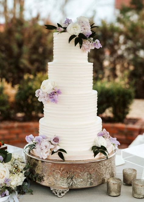 Hanging #wisteria, statuesque columns, and a gorgeous winding staircase make this #Texas wedding just about as timeless as they come. #WeddingVenue #WeddingPlanner #WeddingPlanning #WeddingIdeas #WeddingInspo #WeddingInspiration #Travel #Ceremony #Reception #Bride #Groom #WeddingDress #WeddingCake #TableDecor #Flowers #Centerpieces Bridesmaid Dresses Cream, Wedding Colors 2025, Wedding Cake Purple Flowers, Wedding Cakes Lilac, September Wedding Colors, Light Purple Wedding, Woodbine Mansion, Lavender Wedding Theme, Lavender Wedding Cake