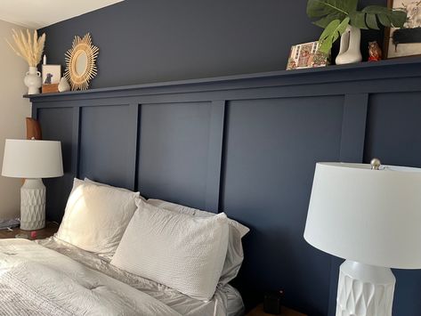 Molding Headboard Wall, Headboard And Wall Same Color, Navy Bedroom Panelling Wall, Board And Batten Shelf Decor, Shelf Above Board And Batten, Panelling Headboard Bedroom, Panelled Wall Behind Bed, Navy Wall Panelling Bedroom, Applied Molding On Walls Bedroom