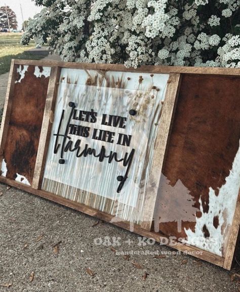 This sign is for my western friends! This sign is personalized and the options are limitless. Add your last name, baby's name for a nursery, favorite lyrics, and/or phrases. This sign has a stained wooden frame with cowhide and dried florals. The acrylic lays over the dried floral with laser cut wording for even more dimensions. This sign is sleek but at the same time rustic. Cowhide pattern may vary sign to sign.  Turnaround time is 6 weeks from ordering to the time your sign will be shipped. N Signs With Cowhide, Cute Western Signs, Family Western Sign, Western Nursery Name Signs, Ranch Family Sign, Baby Room Signs, Cowhide Pattern, Western Signs, Western Nursery