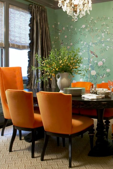 A colorful green, classic dining room is overflowing with personality thanks to statement De Gournay Earlham wallpaper and bold orange dining room chairs designed by Massucco Warner. As seen in "Traditional Home Magazine". Traditional Home Living Room, Orange Dining Room Chairs, Gournay Wallpaper, Orange Dining Room, Orange Chairs, De Gournay Wallpaper, Traditional Home Magazine, Orange Dining Chairs, Green Dining Room