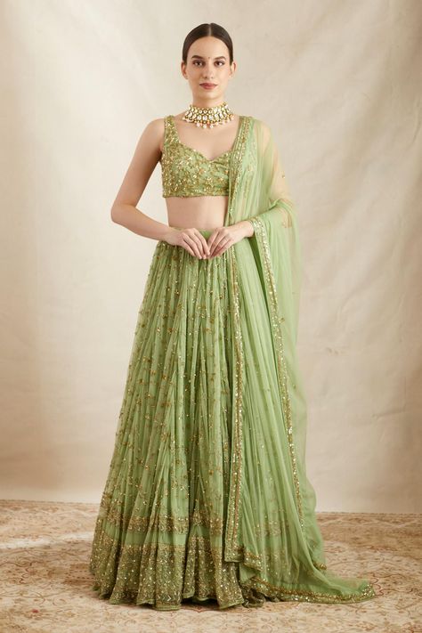 Mint green attached can can lehenga with floral embroidery in sequin, cutdana and sitara. Paired with embroidered, padded blouse and embroidered dupatta. Components: 3 Pattern: Embroidered Type Of Work: Nakshi, Cutdana, Sitara Neckline: V Neck Sleeve Type: Sleeveless Fabric: Nylon, Net, Crepe Color: Green Other Details: Floral pattern Sheer back blouse Lehenga Length: 44 inches Occasion: Bride,Wedding - Aza Fashions Simple Lehenga Designs Unique, Floral Gowns Indian, Green Indian Outfit, Unique Indian Outfits, Unique Lehenga Designs, Simple Lehenga Designs, Astha Narang, Mint Green Skirts, Heavy Lehenga