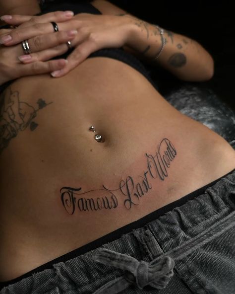 160 Exploring the Beauty of Women’s Stomach Tattoos: Designs and Inspiration - Psycho Tats Women’s Face Tattoo Ideas, Stomach Name Tattoo, Beautiful Words Tattoo, Side Of Torso Tattoos, Stomach Tatoos Woman, Below Belly Button Tattoo, Script Stomach Tattoo, Lower Back Name Tattoos, Sick Back Tattoos