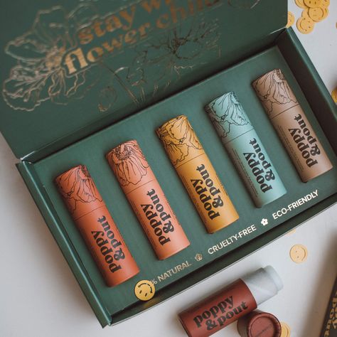 Let’s play the greatest hits! These five are famous for a reason: they’re Poppy & Pout classics. Grab our tried and true go-tos that have been selling out since day one. Includes Sweet Mint, Island Coconut, Pomegranate Peach, Wild Honey, and Orange Blossom. Get in touch with your inner flower child with our vintage inspired, 100% natural lip balms. Each balm is hand poured into beautifully designed, 100% recyclable cardboard tubes. Net Weight per Tube: .3oz / 8.5g Lip Balm Packaging, Mint Lip Balm, Peach Lip Balm, Honey Lip Balm, Coconut Lip Balm, Honey Packaging, Sweet Mint, Cosmetic Packaging Design, Makeup Package