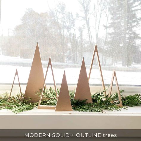 Modern and minimalist tree shapes for a modern Christmas window decor. Beautiful natural wood color or break open the paints and decorate in your own personal style. A great craft project for kids and adults alike. Or add wooden trees to your woodland nursery. Sold in sets of 3unfinished Wooden Trees for Modern Christmas Decor for windows, shelves and fireplace mantlesMODERN SOLID and MODERN OUTLINE tree sizes:small 2.5" wide x 6" tallmedium 3.5" x 8 inches talllarge 4.5" wide x 10.5" tallTRADIT Christmas Decoration Minimalist, Modern Christmas Village Display, Modern Church Christmas Decor, Modern Minimalist Christmas Tree, Minimalist Christmas Trees, Wooden Christmas Decorations Diy, White And Wood Christmas Tree, Wood Christmas Crafts To Sell, Minimalist Christmas Decorations