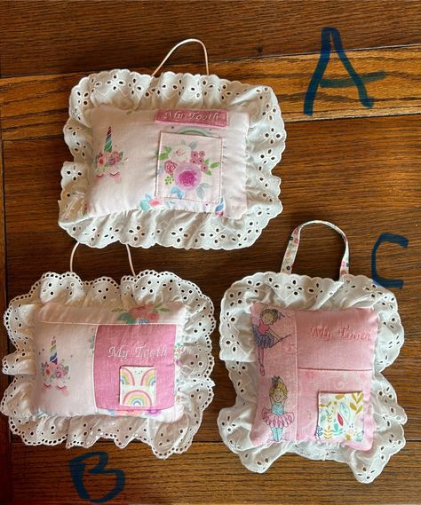 I made these tooth fairy pillows with cotton fabrics, eyelet lace, and used polyfil for stuffing.  The pillow can be added decor in child's bedroom on the bed, shelf, or hang from a doorknob with the added handle.  The tooth pocket is lined and all of the pillow is machine stitched.  This pillow measures approximately 6" x7" and makes a great baby shower gift.  Each one is unique.  Also, the Tooth Fairy really appreciates the help and convenience of easy finding the little one's lost tooth! Waldorf Tooth Fairy Pillow, Tooth Fairy Pillow Pattern Free, Tooth Fairy Pillow Pattern, Bed Shelf, Fairy Pillows, Homemade Pillows, Tooth Fairy Pillows, Fairy Room, Vintage Doilies