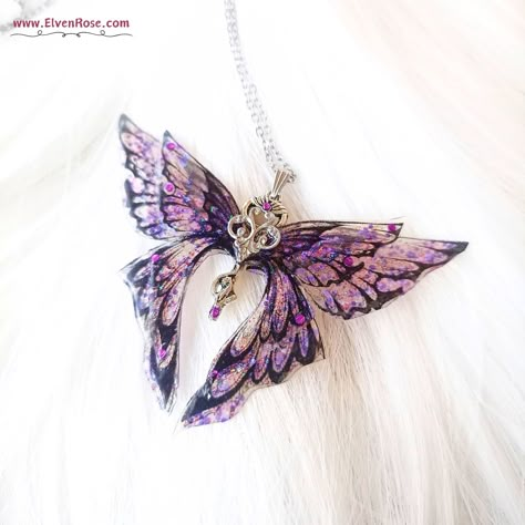 **Discover the Magic Unveil the enchanting allure of the "Magic Butterfly" pendant by Elven Rose, where the wonders of nature and magic intertwine. This exquisite piece features glittering resin wings in delicate shades of purple, capturing the essence of twilight. The silver scepter body, adorned with shimmering violet Swarovski crystals, adds regal elegance, while a watchful cat at the base embodies a guardian of dreams. **Key Features - Glowing Wings: As night falls, the butterfly's wings glo Purple Butterfly Jewelry, Purple Fairy Jewelry, Purple Butterfly Necklace, Glowing Wings, Magical Purple Pendant Necklace, Magic Butterfly, Purple Fairy Necklace, Crystal Butterfly Necklace, Purple Wings