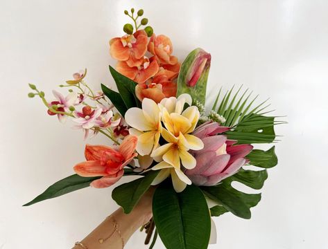 Colors orange, yellow, pink, green, etc. Flowers & Foliages plumeria, palm, protea, anthurium, monstera, etc. Material silk flowers, faux foliage, etc.  Introducing our exquisite Tropical Wedding Bouquet, an exquisite blend of vibrant colors and tropical blooms sure to add a touch of island paradise to your special day! This stunning arrangement features a perfect balance of plumeria, palm, protea, anthurium, and monstera leaves, each hand-selected to create an unforgettable bouquet. Radiating t Asian Flower Bouquet, Tropical Leaf Bouquet, Tropical Bohemian Wedding, Fall Tropical Wedding, Hawaiian Wedding Bouquet, Colorful Tropical Wedding, Hawaii Wedding Flowers, Tropical Flower Bouquet, Plumeria Bouquet