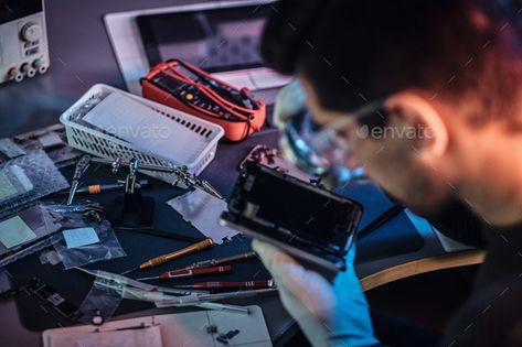 Electronic technician repair damaged smartphone in the workshop by fxquadro. The technician carefully examines the integrity of the internal elements of the smartphone in a modern repair shop #Sponsored #smartphone, #workshop, #fxquadro, #damaged Electronic Technician, Electronic Repair, Repair Shop, Nanotechnology, Vr Goggle, Fitbit, Adobe Illustrator, Illustrator, Smartphone