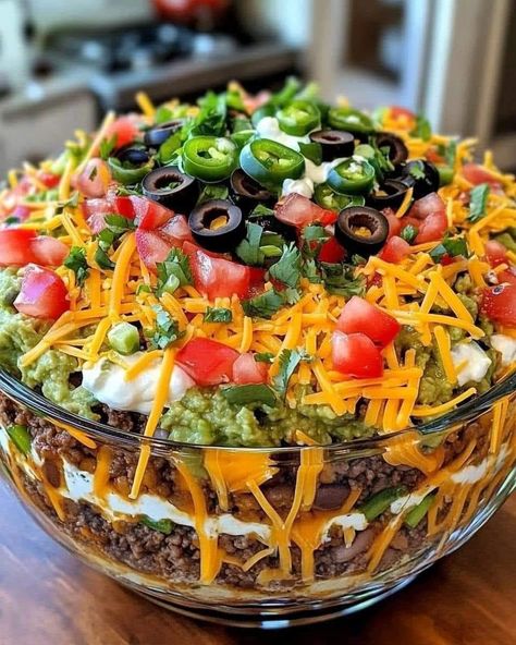 🌮🥗Seven-Layer Taco 🥗 🌮 Ingredients: 1 can of refried beans/ Ground Beef 1 cup sour cream 1 cup salsa 1 cup shredded cheddar cheese 1 cup shredded lettuce 1/2 cup diced tomatoes 1/2 cup sliced black olives 1/4 cup chopped green onions 1/2 tsp ground cumin 1/2 tsp garlic powder Salt and black pepper to taste Tortilla chips (for serving) Directions: Prepare the Layers: In a small bowl, mix the sour cream with ground cumin, garlic powder, salt, and black pepper. Assemble the Salad: Spread t... Layer Taco Salad, 7 Layer Taco Dip, Layered Taco Salads, Taco Salad Ingredients, Seasoned Sour Cream, Layered Taco Dip, Seven Layer Dip, Taco Salad Recipes, Layered Salad