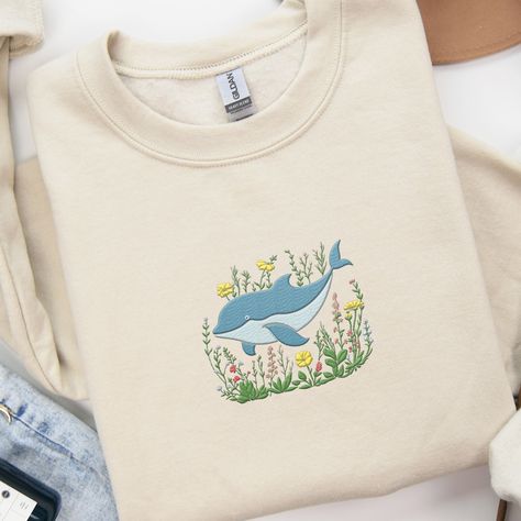 𝑬𝒎𝒃𝒓𝒐𝒊𝒅𝒆𝒓𝒆𝒅 𝑫𝒐𝒍𝒑𝒉𝒊𝒏 𝒔𝒘𝒆𝒂𝒕𝒔𝒉𝒊𝒓𝒕 🐬 🐬 This adorable and whimsical dolphin Sweatshirt is a great addition to your all season wardrobe! It's prefect for taking a walk, running errands, chilling at home, or hanging out with friends! Our crewnecks are made from the highest quality fabric for an incredibly soft and comfortable fit. You can find the sweater in my Etsy Shop 🤍 👉🏻link in Bio #embroiderydesigns #embroideredart #embroidery #sweatshirtforwomen #embroidered #embroiderywork #EmbroideryLove ... Dolphin Sweatshirt, Ocean Sweatshirt, Hem Embroidery, Sunset At The Beach, Aesthetic Sweatshirt, Animal Sweater, Floral Aesthetic, Cute Whales, Animal Sweatshirt