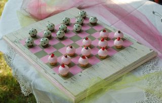 Polymer clay cupcakes on a distressed checker board. Clay Chess Board Diy, Air Dry Clay Checkers Board, Clay Board Game, Homemade Checkers Game, Handmade Clay Chess Set, Clay Chess Set, Clay Chess Pieces, Ceramic Checkers Board, Clay Checkerboard