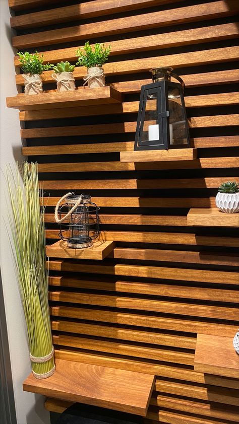 This wall design, made from black Valcromat and Iroko, brings not only nature & warmth into any room, it also can serve as a shelving unit. #walldesign #wooddesign #shelvedesign #woodwall #interiordesign Slat Wall With Moveable Shelves, Wood Slat Shelf Wall, Horizontal Wood Slat Wall With Shelves, Wood Slate Accent Wall With Shelves, Horizontal Wood Slat Wall Bedroom, Slatted Wall With Shelves, Wood Panel Wall With Shelves, Horizontal Wall Slats, Slate Wall With Shelves