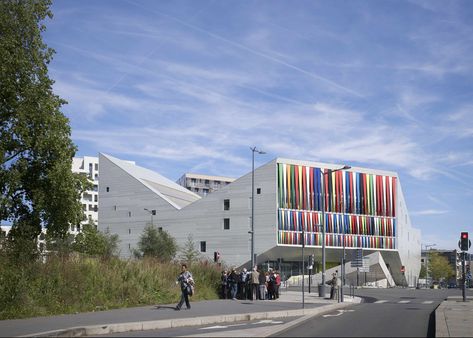 Brightly coloured stripes cover one face of this bulky concrete complex in Lille, designed by architect Julien De Smedt to host community facilities Youth Hostel, Lille France, Northern France, Youth Center, Mix Use Building, Public Building, Architecture Office, Modern Buildings, Modern Exterior