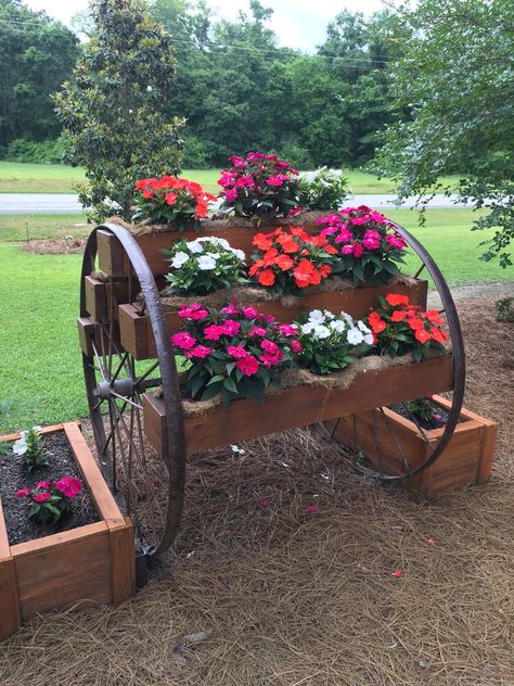 Love my wagon wheel planter built by my husband with idea from Pinterest. Wagon Wheel Garden, Outdoor Planter Ideas, Wagon Wheel Decor, Vintage Pots, Garden Wagon, Modern Arrangements, Wheel Decor, Front Yard Garden Design, Garden Decor Projects