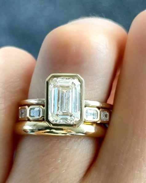 GOODSTONE on Instagram: "Our beloved Penumbra Bezel Set Engagement Ring💍 with an Emerald Cut seen two ways in: Yellow Gold and Blackened Rhodium. ✨Which style would you wear? Share this with someone who would love these rings💕  #engagementring #engagementrings #emeraldcutdiamond #emeraldcutdiamonds #emeraldring #bezelsetting #goodstone" 3 Engagement Rings, Bezel Emerald Engagement Ring With Wedding Band, Bezel Wedding Ring Stack, Emerald Engagement Ring Bezel Set, Emerald Bezel Engagement Ring Stack, Wedding Bands With Bezel Engagement Ring, Bezel Emerald Engagement Ring Stack, Emerald Bezel Engagement Ring With Band, Emerald Ring Set