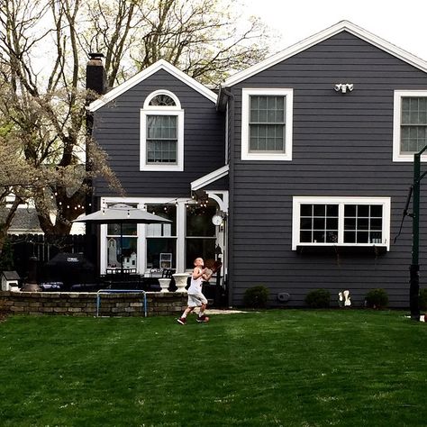 “Our Sunday mornings involve playing outside in the backyard! On a side note...I haven't planted any spring flowers back here yet. I hoped I wouldn't be…” Grey House Paint, Grey House White Trim, Gray Shutters, Painting Vinyl Siding, Dark Grey Houses, Grey Exterior House Colors, White Farmhouse Exterior, Exterior Gray Paint, Gray House Exterior