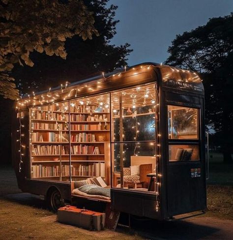 A pull along trailer that used to be enclosed, now has windows all over and inside is a library of books lining the walls. On the floor is a mat and setup to sleep, and in the corner a comfy chair. Little string lights line the top and sides of most of the windows while a large block of wood stands at the side as a stair. Dream Library, Mini Library Outdoor, Small Library Nook Ideas, Reading Shed, Outdoor Library, Book Truck, Book Van, Tiny Library, Mini Library