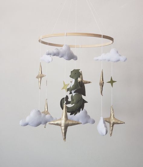 Baby mobile with dragon is perfect decoration for a baby girl or boy nursery room. This mobile its a one of a kind final touch to your new little one.Simply,delicate decoration for nursery. Mobile includes  6 gold stars  6 white clouds Green dragon  Diameter of the hoop 10 inches Crib arm attachment  is not included! Fairy Forest Nursery Theme, Elven Themed Nursery, Dragon Mobile Baby, Cottagecore Nursery Fairy, Dragon Nursery Boy, Dnd Nursery Theme, Fairy Tale Nursery Theme, Dragon Baby Nursery, Magical Forest Nursery