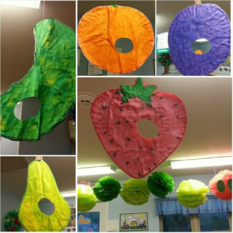 Preschool Toddler classroom: The Very Hungry Caterpillar ceiling decor! Caterpillar made of huge tissue paper poms & food hanging made out of coffee filters painted with watercolors :) by far one of our greatest classroom projects! Tied in to our tods exploring fruits and veggies :) Caterpillar Craft Preschool, Hungry Caterpillar Food, Hungry Caterpillar Classroom, Caterpillar Preschool, Tissue Paper Poms, Eric Carle Classroom, Caterpillar Activities, The Very Hungry Caterpillar Activities, Hungry Caterpillar Craft