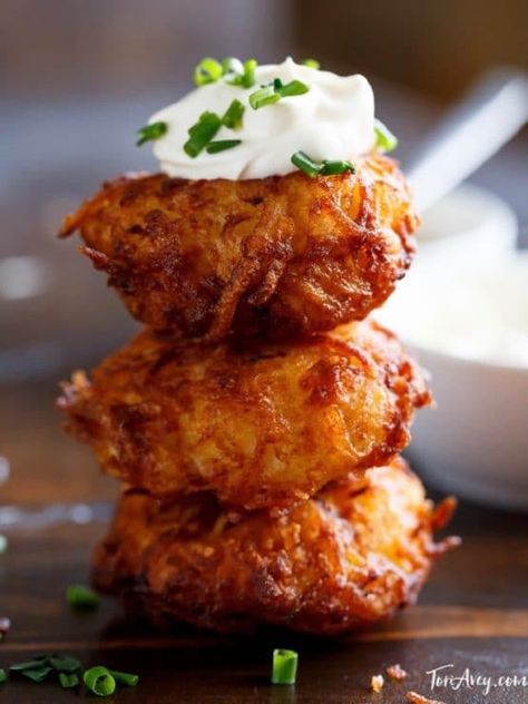 Tower of three potato latkes topped with sour cream and chives. Essen, Jewish Recipes, Jewish Holiday Recipes, Kosher Cooking, Hanukkah Food, Potato Latkes, Vegan Recipes Videos, Kosher Recipes, Potato Dishes