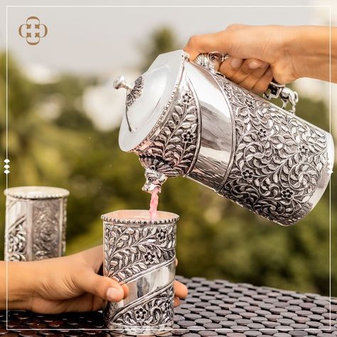 A great addition to a cozy family picnic or a festive holiday party with friends, this Silver Water Jug Set is a versatile household highlight for your home. This opulent design features a sleek curved handle and intricate, hand-embossed floral detailing. Video call Facility available for NRI Clients along -Safe and Secure Shipping -92.5 Pure Silver -Wide range of collection in Each Category +91 9094949409 Silver Water Jugs, Silver Home Accessories, Silver Jug, Party With Friends, Pooja Items, Silver Pooja Items, Silver Water, Family Picnic, Dinner Set