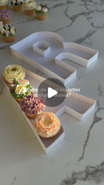 Custom Floral Cupcakes & Workshops | Adelaide 🇦🇺 on Instagram: "Want to create your own monogram letter cupcake boxes? This is now available as a digital download on my Etsy store 🎉   ➡️ comment ‘link please’ and I’ll DM the link straight to your inbox 🫶🏻  ➡️ comment ‘bundle’ if you would like the letter AND number templates. Plus you get the BONUS engagement ring 💍 and heart shape 🤍 box in this option.  Includes: 🌸 Full size templates 🌸 Easy to follow step-by-step instructions with pics 🌸 Materials list and where to purchase  🌸 Cupcake placement guide + more!  Each letter is around 12” tall and 2 boxes fit perfectly in a 24 cupcake box for beautiful presentation 🙌🏼  #adelaidebaker #monogrambox #digitaldownload #digitaldownloads #boxletters #floralcupcakes #cupcakeboxes #butte Number Shaped Cupcakes, Number 12 Cupcakes Design, Number Cake With Cupcakes, Cupcake Box Decoration Ideas, Letter Cupcakes Ideas, Cupcake Letter Boxes, Number 70 Cupcake Cake, Cupcake Letter Cake, Cupcakes With Letters On Top