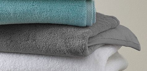 The arrangement of bath towels in a bathroom can make a major statement. Here's a handy guide to help you color coordinate like a pro. Grey Bathroom Towels Ideas, Towels For Grey Bathroom, What Colour Towels For A Grey Bathroom, Grey Towels Bathroom Decor, Bath Towel Color Schemes, Bathroom Towel Colors, Towel Colors For Bathrooms, Bathroom Towel Colors Scheme, Bath Towels Display