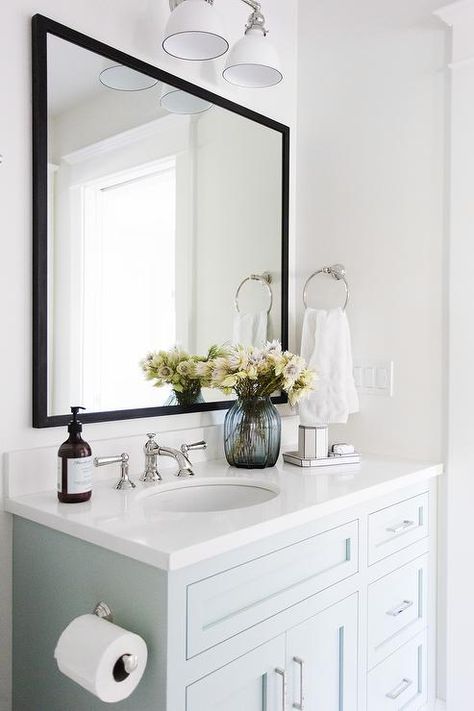 Lit by a white two light sconce, a pale blue vanity painted Benjamin Moore Woodlawn Blue is accented with a white quartz countertop holding a round sink with a polished nickel faucet kit beneath a black mirror mounted on a white wall beside a polished nickel towel ring. Blue Cabinet, Tiled Shower, Gorgeous Bathroom, White Vanity Bathroom, Perfect Blue, Trendy Bathroom, Girls Bathroom, Bathroom Storage Cabinet, Blue Bathroom