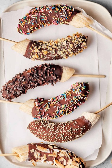 If you love the taste of chocolate and bananas, then you are going to love this recipe! My Frozen Chocolate Banana Pops are a a simple and easy way to enjoy a healthy, delicious sweet treat! As the weather begins to warm up, these are the perfect way to cool down and ease into the spring and summer months!A plate lined with parchment paper and six of the frozen chocolate banana pops Banana With Chocolate, Waffle Truck, Frozen Banana Treats, Frozen Chocolate Bananas, Banana And Chocolate, Banana Frozen, Choco Banana, Chocolate Lollies, Gluten Free Desserts Healthy